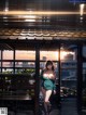 A woman in a green dress standing on a balcony.