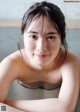 A woman in a bathtub with water droplets on her body.