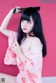 A woman in a pink kimono posing for a picture.