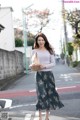 A woman is walking down the street holding a bag.