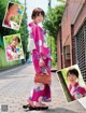 A woman in a pink kimono is walking down the street.