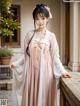 A woman in a pink and white kimono posing for a picture.