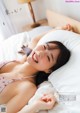 A woman laying on a bed in a pink bikini.